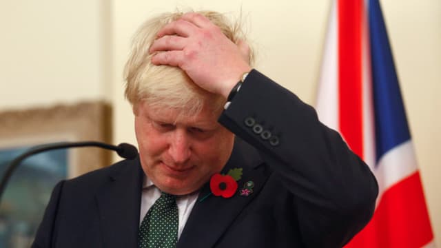 Boris Johnson im Porträt sich die Haare glattstreichend.