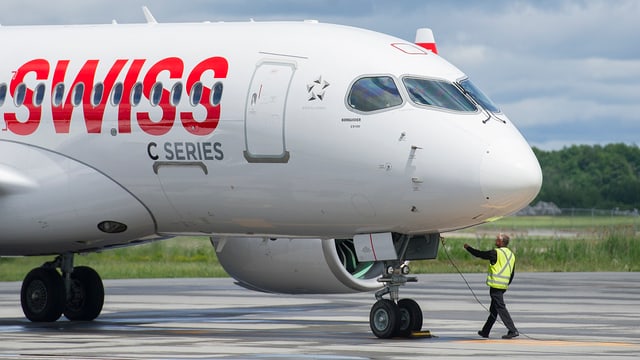 Flugzeugmodell C-Series 100 auf Landebahn, ein Arbeiter steht vorne dran.