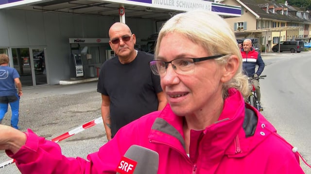 Frau in rosa Jacke gibt ein Interview.