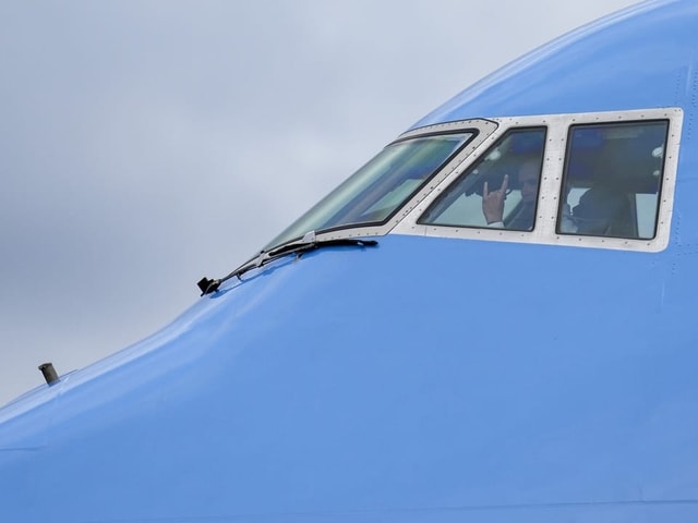 Das blaue Cockpit eines Air-Force-One Flugzeugs von aussen. Der Pilot schaut aus dem Fenster