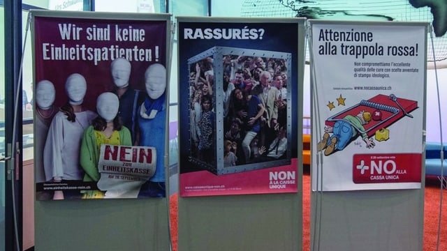 Drei Plakate hängen nebeneinander an grauen Ständer. Alle sind verschieden aber von der gleichen Partei. 