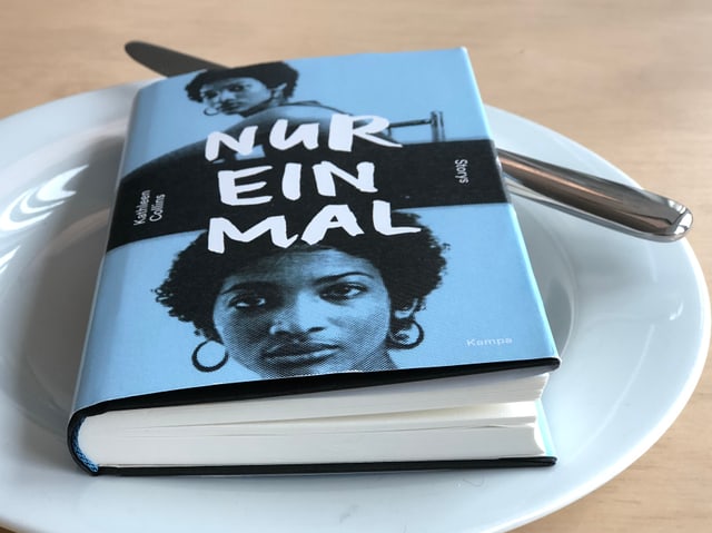 Der Sammelband «Nur einmal» mit Kurzgeschichten von Kathleen Collins liegt auf einem weissen Teller