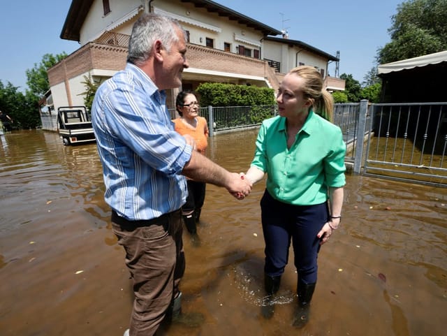 Meloni schüttelt einem Mann die Hand. 