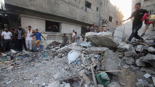 Trümmer in den Strassen von Gaza-Stadt. Leute klettern darauf herum.