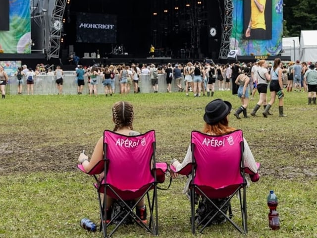 Zwei Frauen sitzen auf dem Campingstuhl vor der Bühne.