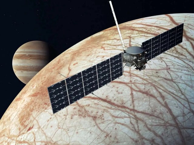 Raumsonde fliegt über Europa mit Jupiter im Hintergrund.