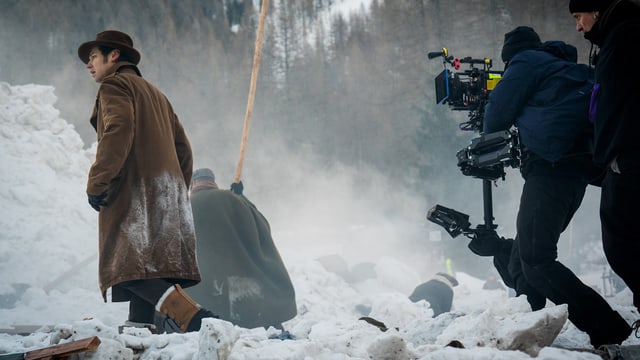 Menschen stapfen durch den Schnee und filmen.