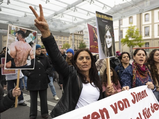 Frauen mit Amini-Bildern und Transparenten-.