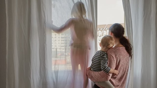 Frau mit Kindern am Fenster