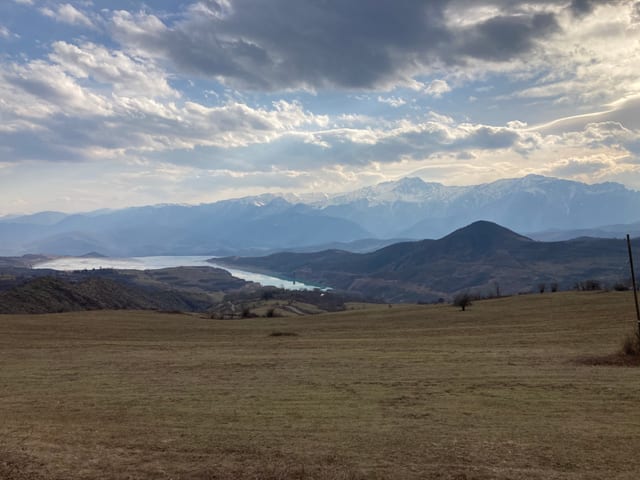 Landschaft und Wolken: Hügel und ein See