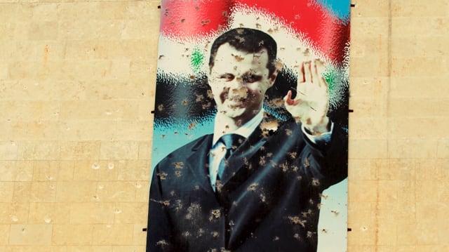 Ein zerschossenes Wandbild des syrischen Präsidenten Bashar al-Assad.