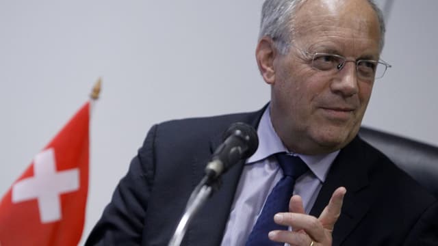 Johann Schneider-Ammann neben einer kleinen Schweizer Fahne