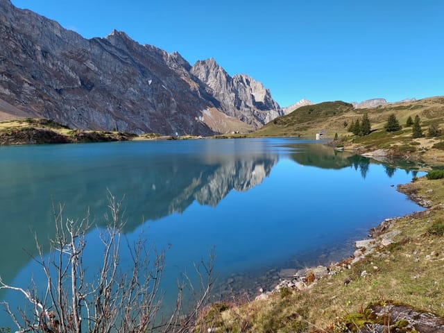 Bergsee mit Spiegelung und blauem Himmel..