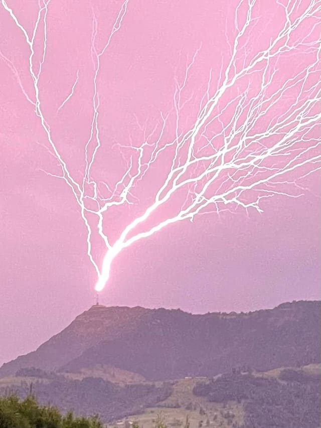 Blitz, der von Bergspitze in den Himmel geht.