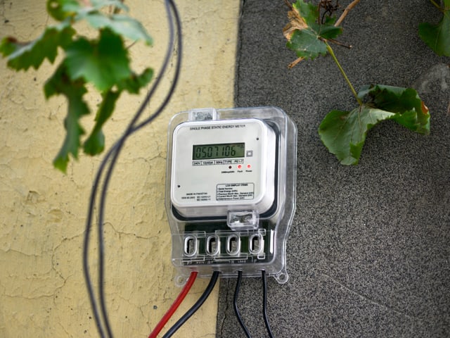 Ein Smart Meter hängt an einer Hauswand