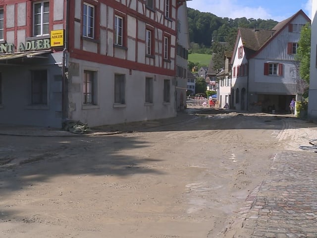 Dorfstrasse mit traditionellen Gebäuden nach Regen.