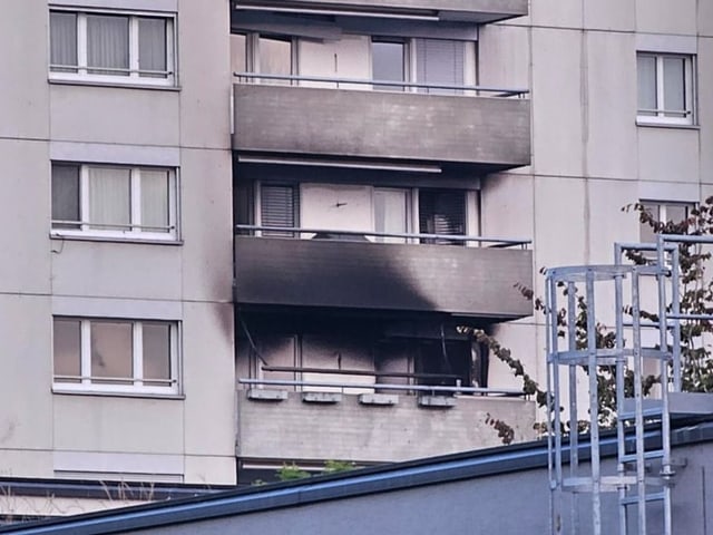 Balkon von Hochhaus mit Brandspuren.