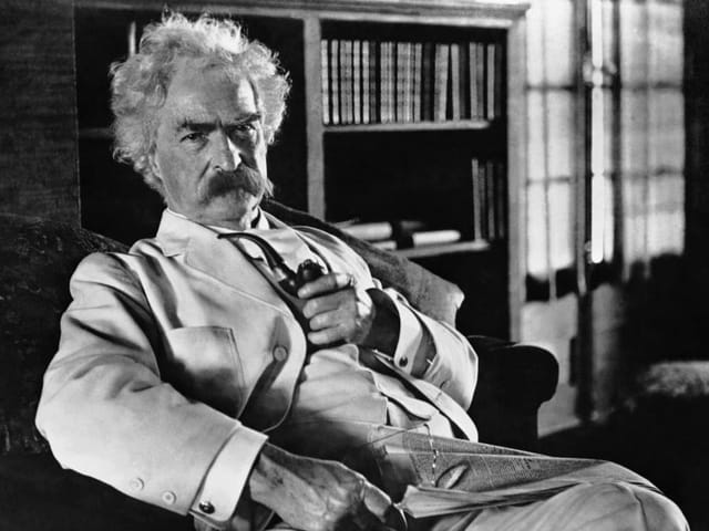 Historisches Bild: Mark Twain mit Pfeife im Sessel.