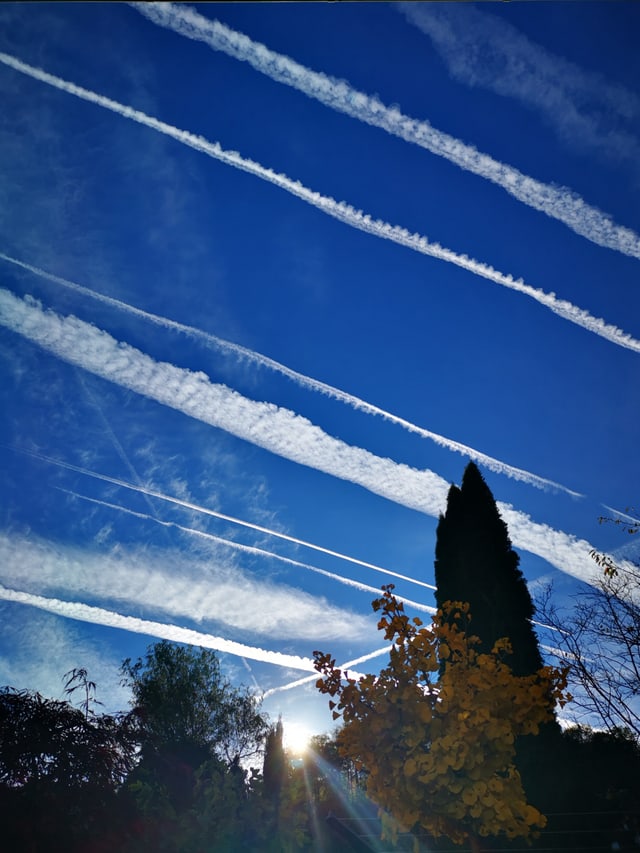 Blauer Himmel mit weissen Kondensstreifen.