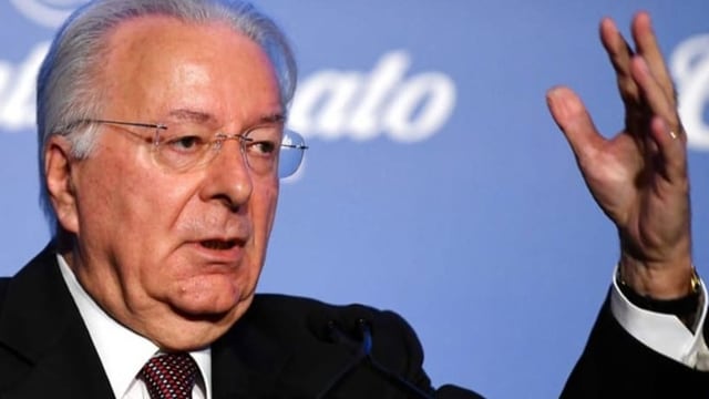 Älterer Herr in Anzug und mit Brille (Federico Faggin) steht an einem Rednerpult