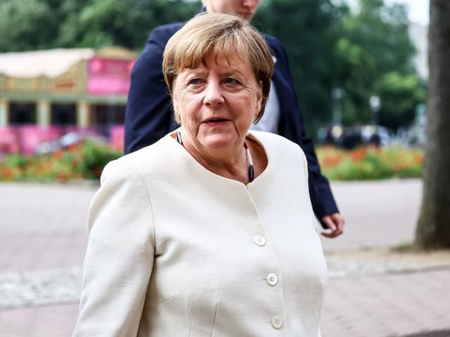 Eine Frau mit kurzem Haar in einem weissen Kleid.