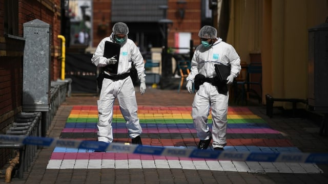 Forensic scientists in suits looking for clues. 