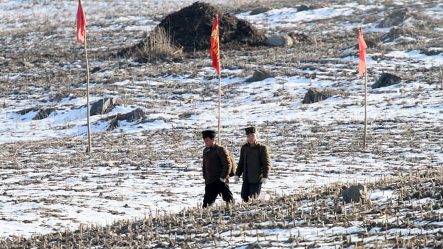 Nordkoreanische Soldaten laufen über ein Feld 