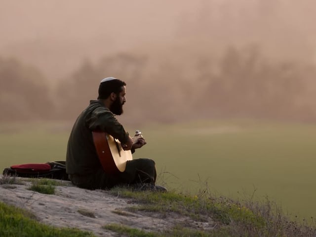 Ein israelischer Soldat spielt Gitarre auf einem Hügel nahe der Grenze zwischen Israel und Gaza.