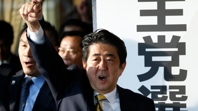 Shinzo Abe reckt die Faust in die Höhe.