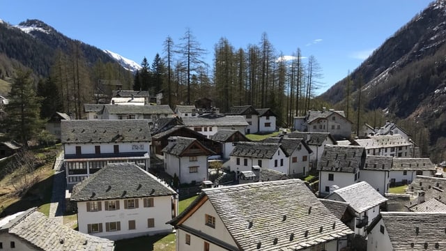 Ein kleines Dorf mit alten Häusern in den Bergen bei schönem Wetter. 