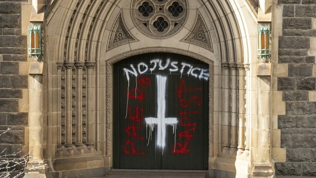 A graffiti on the door of a church shows: the acquittal of Cardinal Pell was not without controversy.
