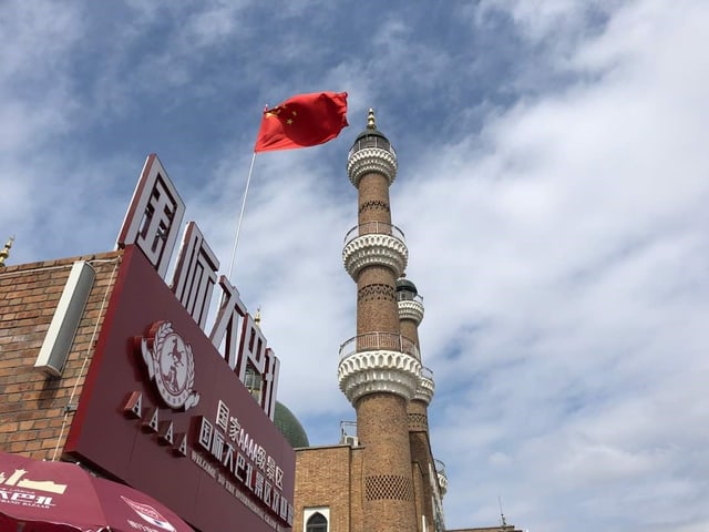 Flagge vor einem Minarett.