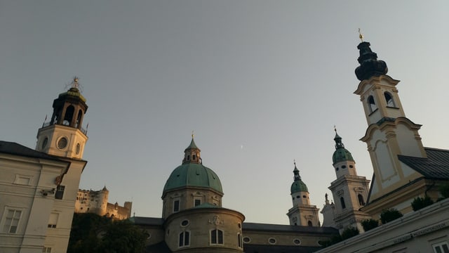 Die Türme mehrerer Kirchen ragen in den blauen Himmel.