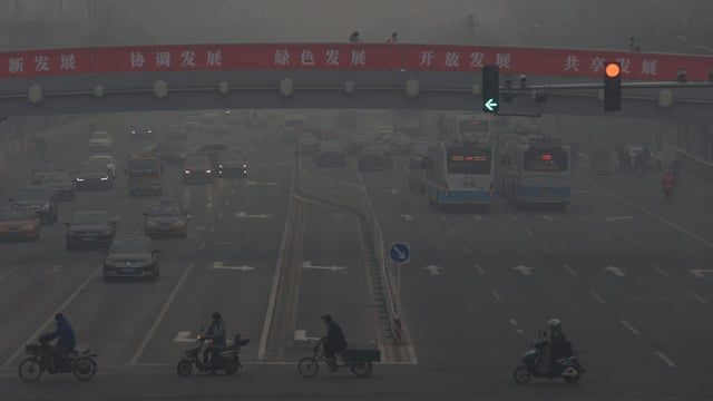 Autos und Motorräder in dichtem Smog in Peking. 