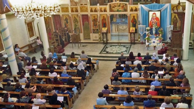 Gläubige sitzen in den Kirchenbänken.