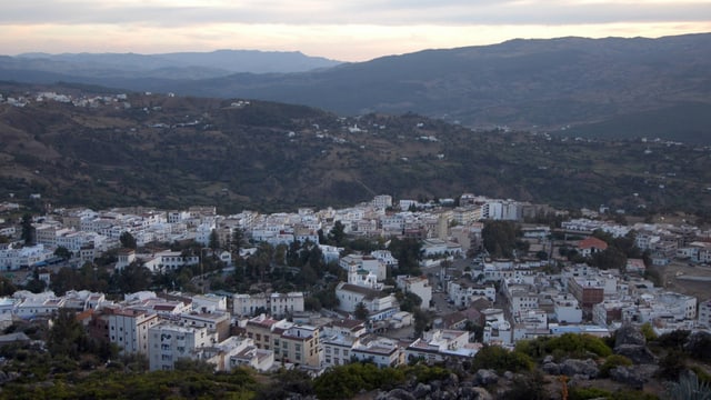 Blick auf dei Stadt Chefchaouen im Rif-Gebirge im Norden Marokkos in der Abenddämmerung.