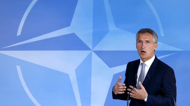 Nato-Generalsekretär Jens Stoltenberg spricht vor einer blauen Nato-Flagge.