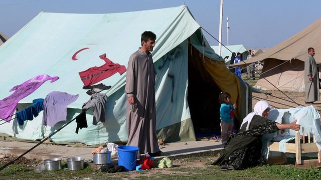 Eine Familie vor einem Zelt in einem Flüchtlingscamp. 