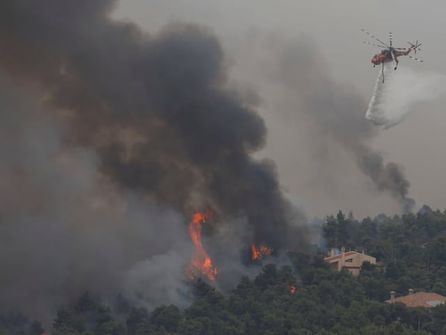 Ein Löschhelikopter wirft Wasser ab