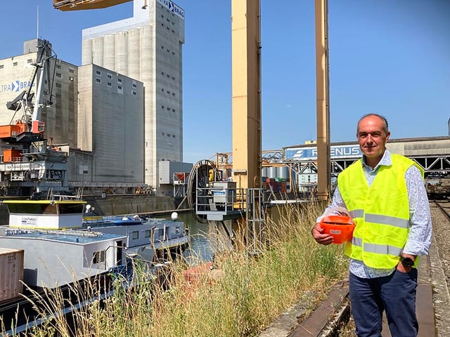 Mann steht vor Rheinhafen-Anlage