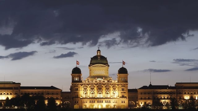 Symbolbild: Dunkle Wolken über dem beleuchteten Bundeshaus in Bern.