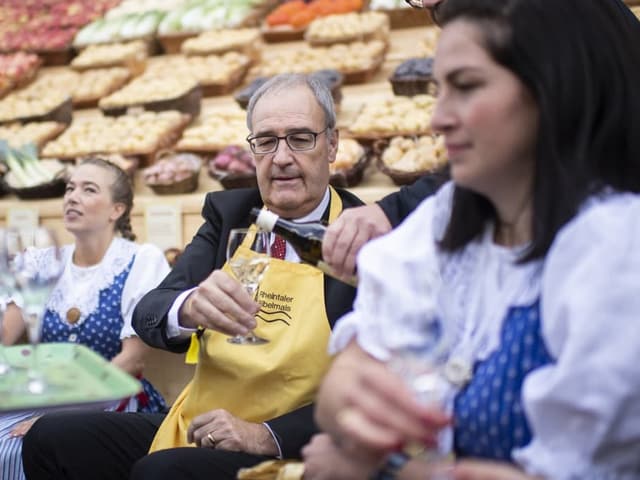 Bundespräsident Guy Parmelin schenkt sich ein Glas Weisswein ein.