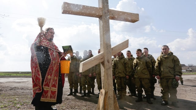 Ukrainische Soldaten und ein orthodoxer Geistlicher in Donezk, nahe der russischen Grenze.