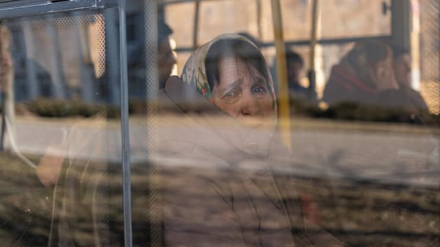 A woman waits on a bus to be evacuated from the city of Brovary near Kyiv.