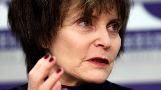 Kopf von Alt Bundesrätin Micheline Calmy-Rey, sie schaut zur Seite, ihre Hände sind gestikulierend erhoben.