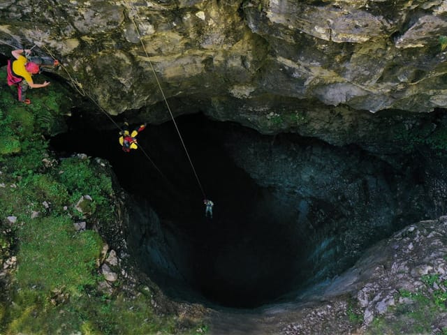 Höhlenforscher seilen sich in grosse Höhle ab.