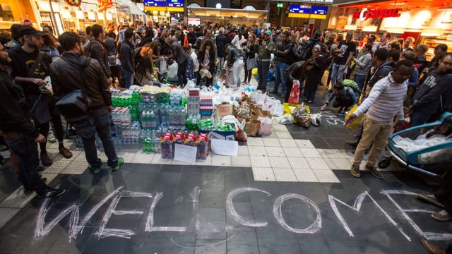 Menschen und Pakete in einer Bahnhofspassage