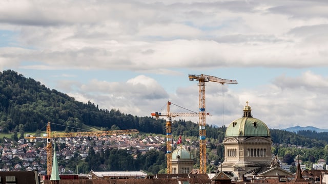 Bundeshaus mit drei Baukränen in der näheren Umgebung.