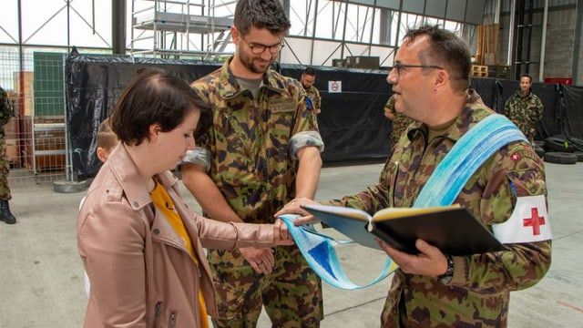 Stefan Staub legt symbolisch ein Band auf die Hände des Verlobungspaares.