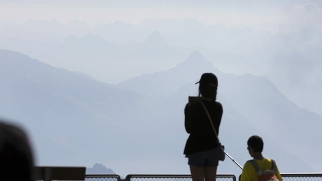 Personen geniessen das Bergpanorama.